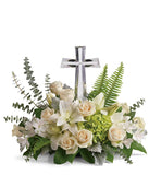 An arrangement of white asiatic lilies, creme roses, and white alstromeria with floral greens and a crystal cross