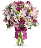 A cheerful floral arrangement featuring pink spray roses, white daisies, green button poms, purple Monte Casino, and limonium, all beautifully arranged in a glass vase with a hot pink ribbon. This vibrant mix offers a playful and lively display.