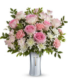 Floral arrangement with pink roses, pink alstroemeria, pink carnations, white cushion spray chrysanthemums, white limonium, and assorted greenery in a keepsake silver vase featuring a cross design.