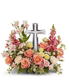 Coral roses, yellow spray roses, pink alstroemeria, creme carnations, mini pink carnations, hot pink snapdragons, and floral greenery with a large crystal cross on top of the arrangement