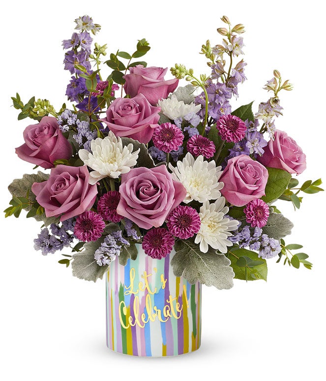 Lavender roses arranged with purple button chrysanthemums, lavender larkspur, lavender sinuata statice, and floral greens in a keepsake 