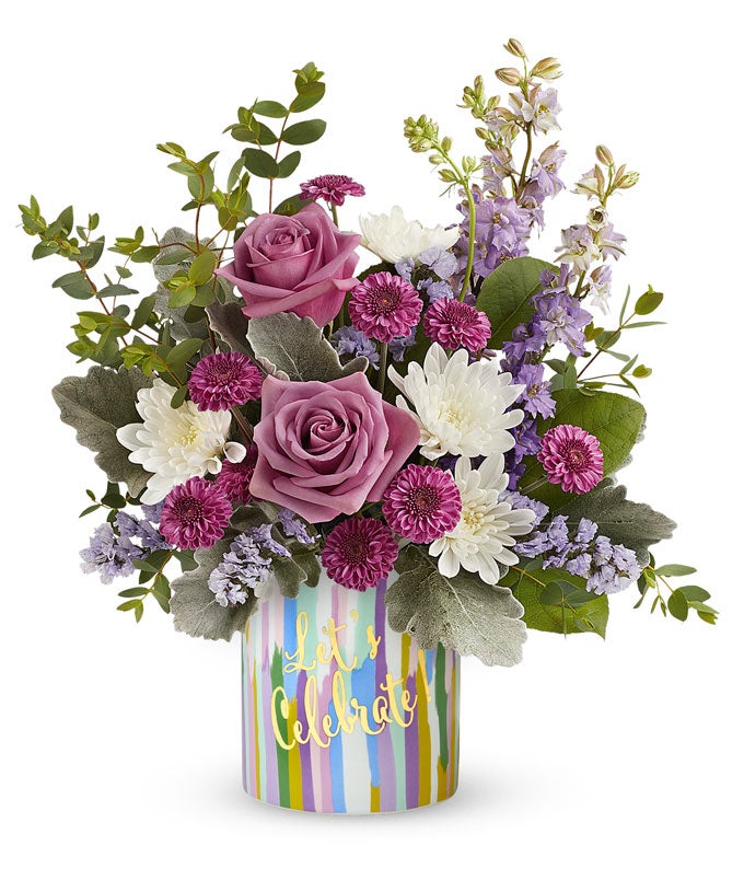 Lavender roses arranged with purple button chrysanthemums, lavender larkspur, lavender sinuata statice, and floral greens in a keepsake 