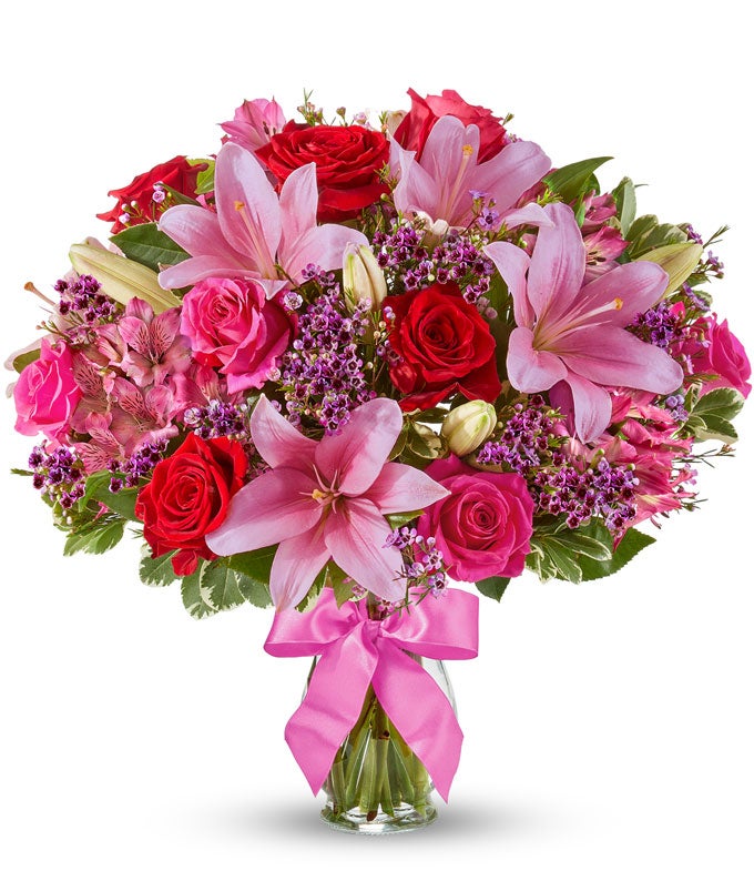 Red roses, pink lilies and pink alstroemeria and glass vase