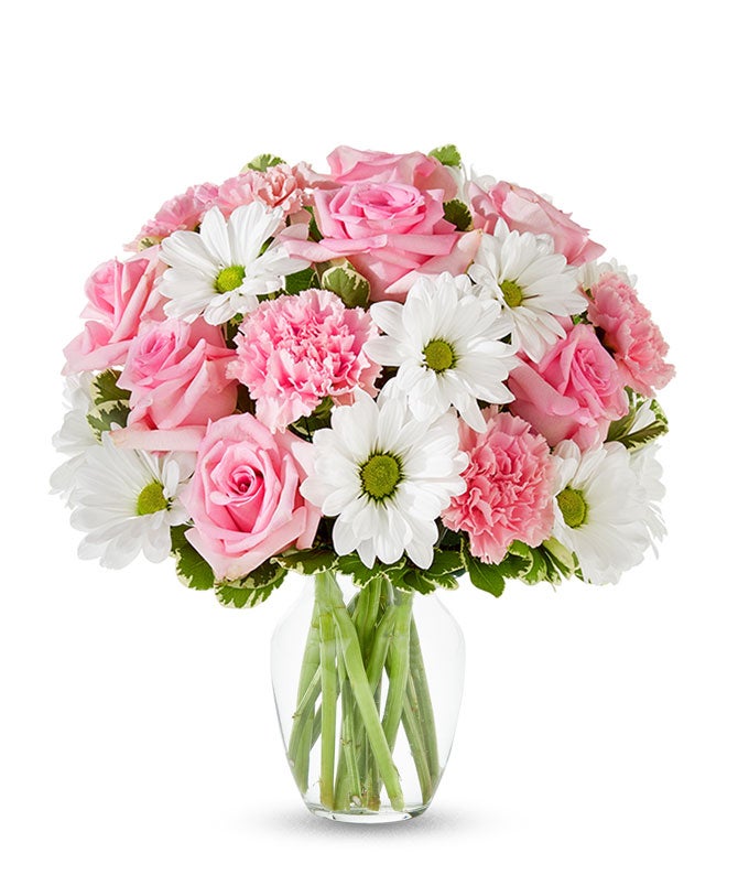 Pink roses, pink carnations and white daisies in a pink vase
