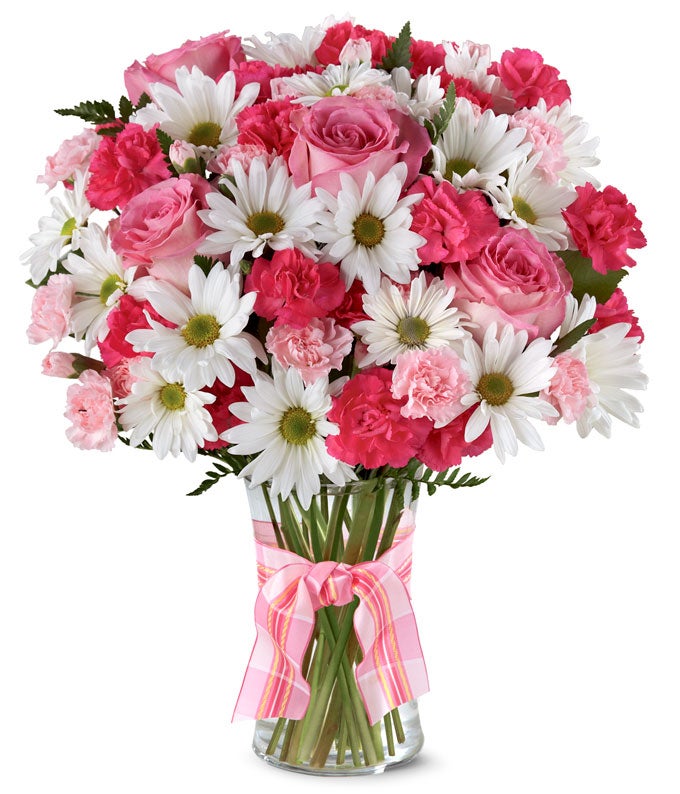 A delightful arrangement featuring hot pink spray roses, white traditional daisies, and pink mini carnations, beautifully arranged in a clear vase with a pink bow. This vibrant mix offers a cheerful and elegant display.