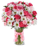A delightful arrangement featuring hot pink spray roses, white traditional daisies, and pink mini carnations, beautifully arranged in a clear vase with a pink bow. This vibrant mix offers a cheerful and elegant display.