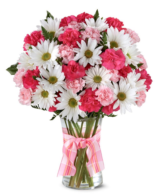 A delightful arrangement featuring hot pink spray roses, white traditional daisies, and pink mini carnations, beautifully arranged in a clear vase with a pink bow. This vibrant mix offers a cheerful and elegant display.